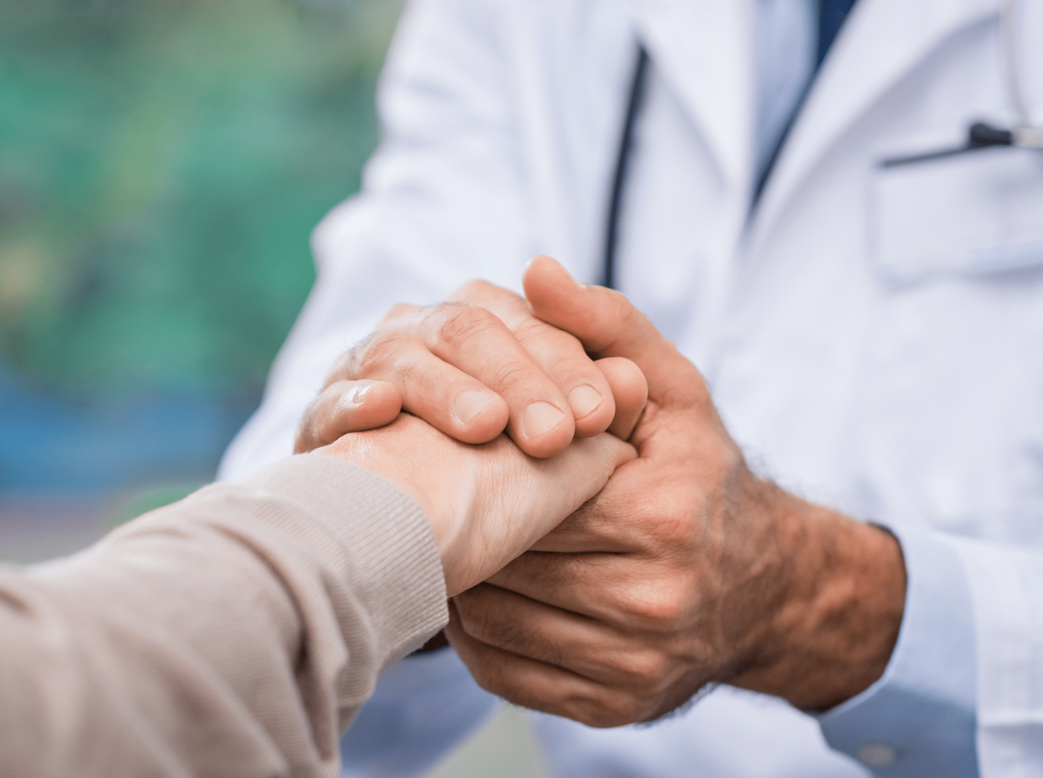 A doctor holding an elderly persons hand